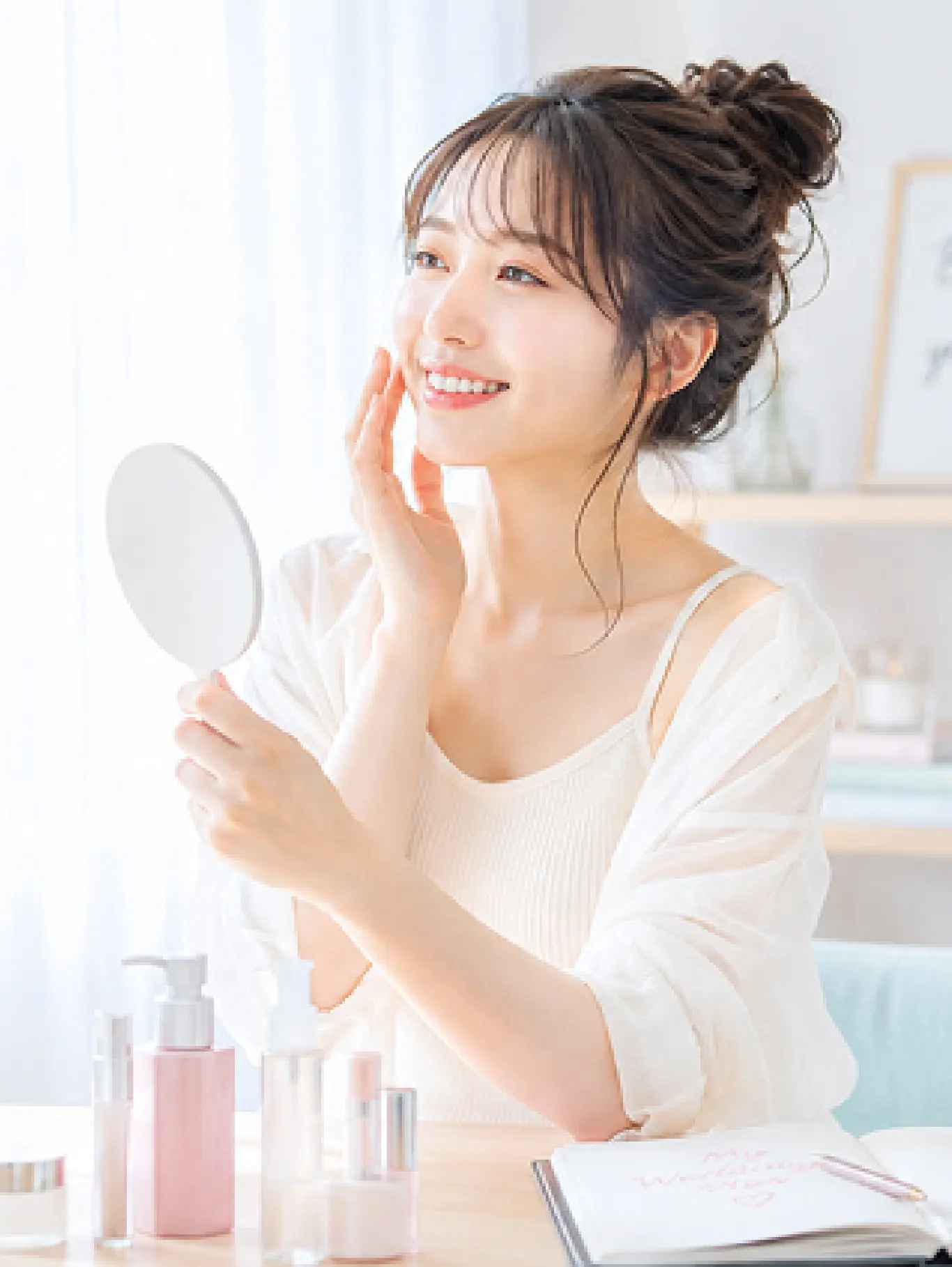 鏡を見ながら嬉しそうに肌をケアする女性