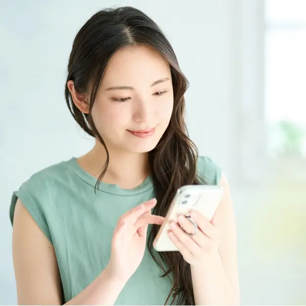 スマートフォンで結婚相談所に連絡する女性